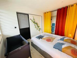 - une chambre avec un lit et des rideaux colorés dans l'établissement La Brise Marine, à Calais