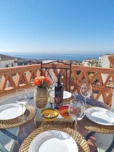 una mesa con platos de comida y una botella de vino en Elegant apartment with fantastic views At the top of Calahonda en Sitio de Calahonda