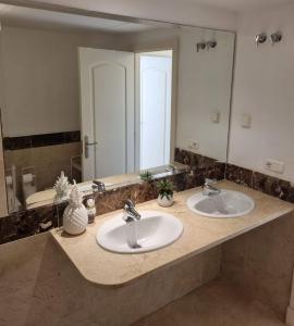 a bathroom with two sinks and a large mirror at Elegant apartment with fantastic views At the top of Calahonda in Sitio de Calahonda