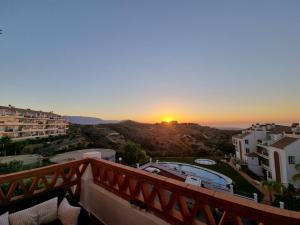 a view of the sunset from the balcony of a building at Elegant apartment with fantastic views At the top of Calahonda in Sitio de Calahonda