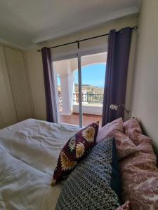 a bedroom with a bed with a view of a balcony at Elegant apartment with fantastic views At the top of Calahonda in Sitio de Calahonda