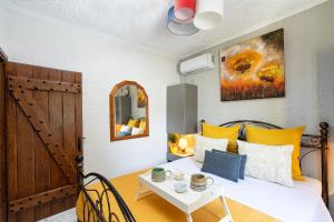 una camera da letto con un letto con cuscini gialli e un tavolo di Rock and Sea View House a Sitia