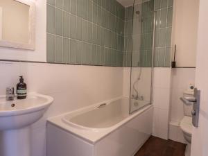a bathroom with a sink and a tub and a toilet at Pass the Keys Beautiful Nottingham home with Private Driveway in Nottingham