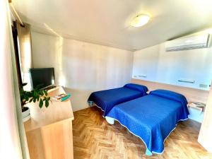 mały pokój z 2 łóżkami i telewizorem w obiekcie Camping Village Tuscia Tirrenica w mieście Tarquinia