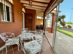 patio con tavolo e sedie sotto il portico di Chalet Oasis a Novo Sancti Petri