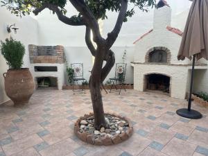 a tree in a courtyard with a fireplace at SEAmpliCITY cozy apartment in Heraklio