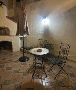 stół, 2 krzesła i parasol w pokoju w obiekcie SEAmpliCITY cozy apartment w Heraklionie
