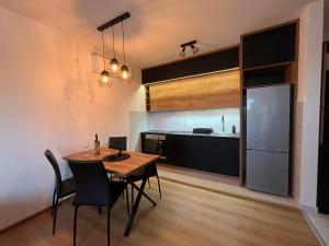 a kitchen and dining room with a table and a refrigerator at Apartman Maša in Ruma