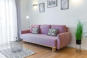 un sofá púrpura en una sala de estar con mesa en Sun Hill Apartments Mlini, en Mlini