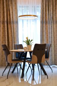 tavolo da pranzo con 4 sedie e una pianta in vaso di Apartment Madonna a Dugopolje (Dugopoglie)