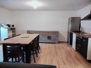 a kitchen with a wooden table and a refrigerator at Grand appartement de 3 chambres moderne et spacieux, entièrement meublé in Belfort +26 photos