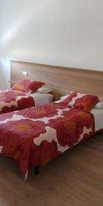1 dormitorio con 2 camas y mantas rojas y blancas en Apartamentos Turísticos Magencio, en Carucedo