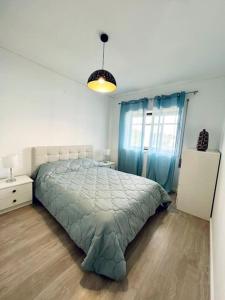 1 dormitorio con 1 cama con edredón azul en Apartamento familiar Praia Barra, en Praia da Barra