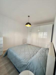 1 dormitorio con 1 cama grande en una habitación blanca en Apartamento familiar Praia Barra, en Praia da Barra