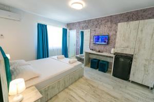 - une chambre avec un grand lit et une télévision dans l'établissement Casa Andrei & Alex 2 Mai, à 2 Mai
