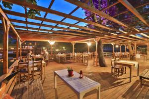 a restaurant with tables and chairs on a deck at Ağva Mints Hotel Adult Only in Ağva