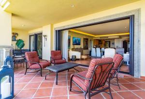 a patio with chairs and a table and a living room at Luxury retreat in Cabo del Sol golf and beach community in Cabo San Lucas