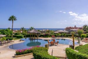 a large pool with chairs and tables in a resort at Luxury retreat in Cabo del Sol golf and beach community in Cabo San Lucas