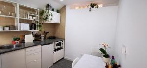 a small kitchen with white cabinets and a sink at Quarto Duplo com Kitchenette, WC e Pátio privativo in Corroios