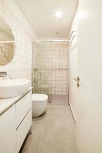La salle de bains est pourvue d'un lavabo, de toilettes et d'une douche. dans l'établissement Pause Apartments, à Porto