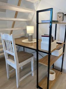 a desk with a chair and a table with a clock at Horizont idéző ParkMotel in Orfű