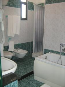a bathroom with a tub and a toilet and a sink at Hotel Ristorante La Scogliera in Amantea +25 photos