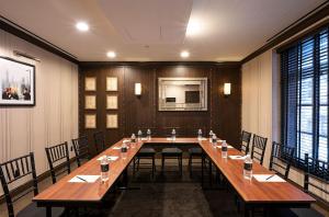 uma grande sala de conferências com uma mesa longa e cadeiras em Iroquois New York Times Square em Nova York