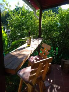 a wooden table with a bottle of wine and two chairs at Bosque Azul Picaflor in Minca