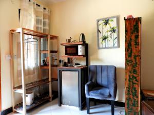 a room with a chair and a desk and a shelf at Jogoo rooms in Dar es Salaam