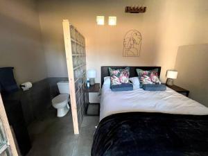 a bedroom with a large bed and a toilet at The Stables in Roodepoort