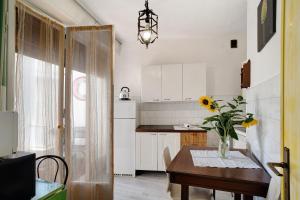 a kitchen with a table with a vase of flowers on it at Rosina's house in Ventimiglia