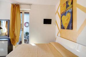 a bedroom with a bed and a tv on a wall at Rosina's house in Ventimiglia