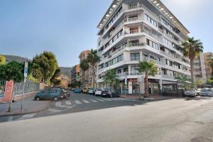 a large white building with cars parked next to a street at Rosina's house in Ventimiglia