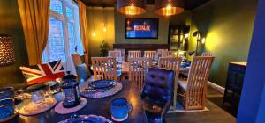 comedor con mesa, sillas y TV en Beresford Cottage en Skegness