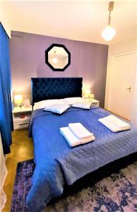 a bedroom with a blue bed with two towels on it at Arc de Triomphe BlissBoutique in Bucharest
