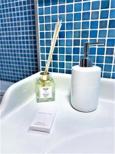 a bathroom with a bottle of perfume and a stick at Arc de Triomphe BlissBoutique in Bucharest