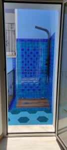 bagno con doccia e piastrelle blu di Appartamenti La perla a Carloforte