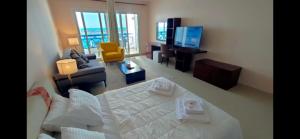 a living room with a large bed and a television at Executive Royal Tower Apartments - Sky Lounge in El Alamein