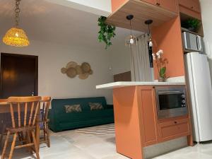 Lindo Apto no Centro de Blumenau في بلوميناو: مطبخ وغرفة معيشة مع أريكة خضراء