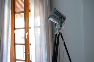 - une télévision sur un tripod à côté d'une fenêtre dans l'établissement Precioso apartamento al lado de la Alhambra, à Grenade