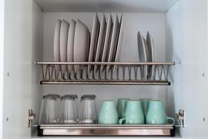 - une étagère avec des assiettes et des ustensiles dans la cuisine dans l'établissement Precioso apartamento al lado de la Alhambra, à Grenade