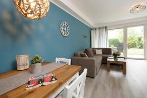 ein Wohnzimmer mit blauen Wänden und einem Esstisch in der Unterkunft Waldstraße 8 Wohnung 1 in Kellenhusen