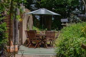 a table and chairs under an umbrella in a garden at Moor View in Lockton
