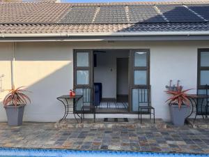 a front porch of a house with two chairs and a table at 2 Op Terblanche Guesthouse in Boksburg