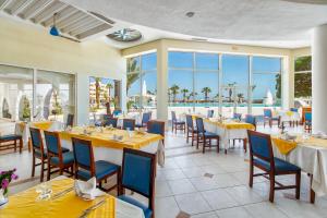 DjerbaにあるBest Time Alkantara Djerbaのテーブルと椅子が備わり、海の景色を望むレストラン