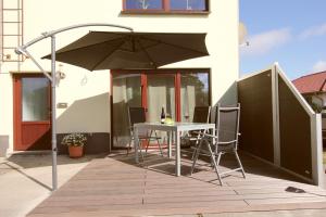 a table and chairs under an umbrella on a deck at Ferienwohnung Franke in Zinnowitz
