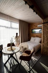 a woman standing in a bedroom with a bed and a table at Le 2800 du Parc in Shawinigan