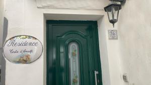 a green door on a building with a sign on it at Appartamento Residence Costa D'Amalfi in Minori