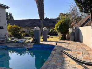 a swimming pool in the yard of a house at 2 Op Terblanche Guesthouse in Boksburg