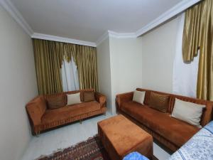 uma sala de estar com dois sofás castanhos e uma mesa em Lovely Specious 2 bedroom suite apartment Near IST Airport Shuttle option em Arnavutköy